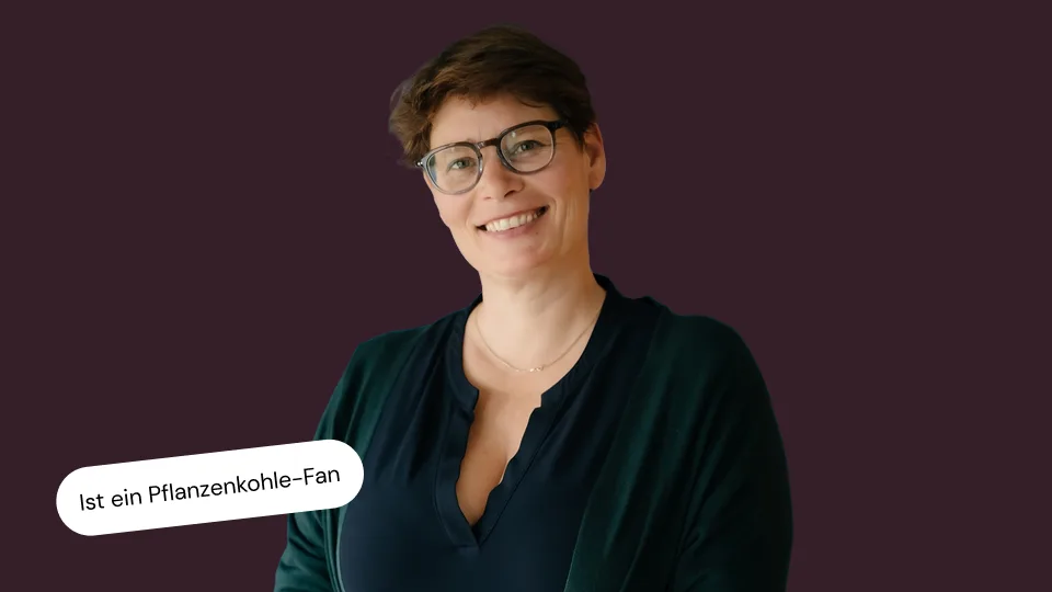 Portraitfoto von Petra von Notz auf einfarbigem dunkelrotem Hintergrund