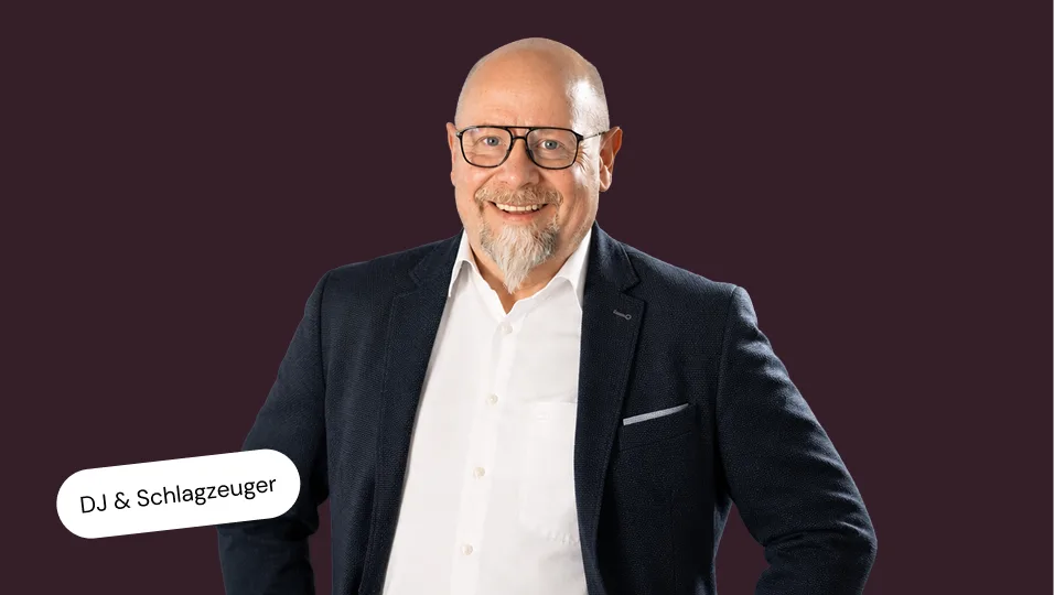 Portraitfoto von Thorsten Krüger auf einfarbigem dunkelrotem Hintergrund
